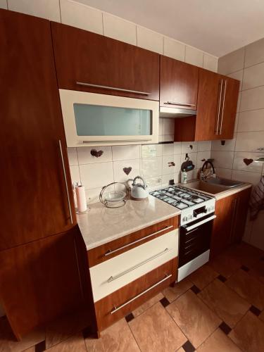 a kitchen with wooden cabinets and a stove top oven at Agroturystyka ‚U Misia’ in Krzywopłoty