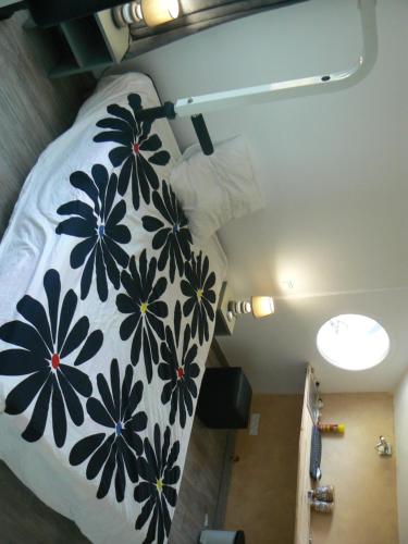 ein Bett mit einer schwarzen und weißen Decke mit Blumen drauf in der Unterkunft VILLA BIARRITZ PROCHE PLAGES in Biarritz