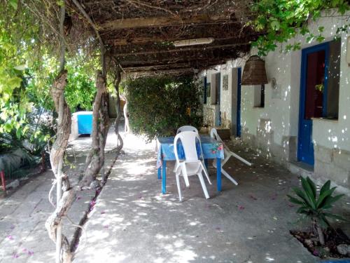uma mesa e cadeiras sentadas à sombra de um edifício em La mia Africa em Favignana