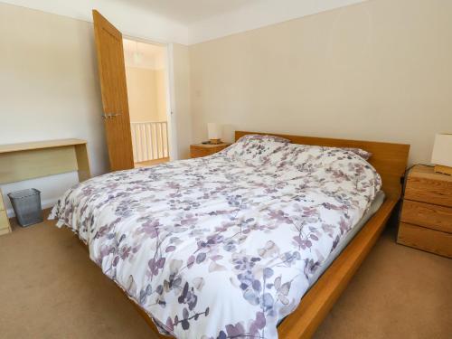 a bedroom with a bed with a floral comforter at 11 Overdale Avenue in Wirral