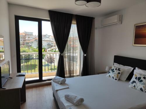 a bedroom with a large bed and a large window at Marina Sarafovo in Burgas City