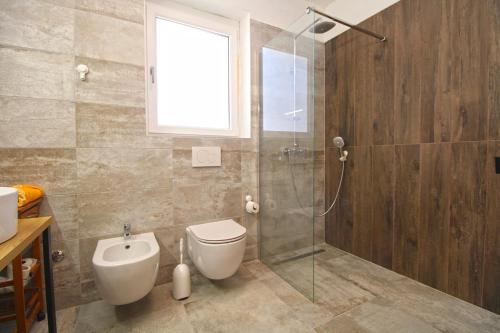 La salle de bains est pourvue de toilettes et d'une douche en verre. dans l'établissement House Medulin 2247, à Medulin