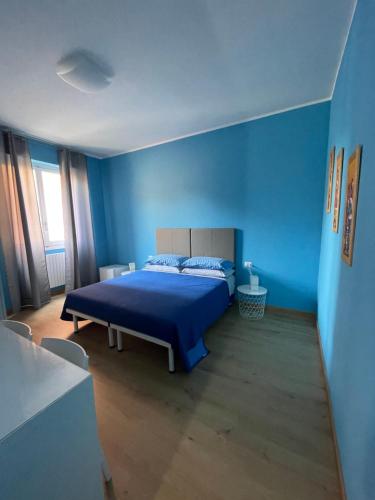 Un dormitorio azul con una cama y una pared azul. en Notti Serene, en Montesilvano