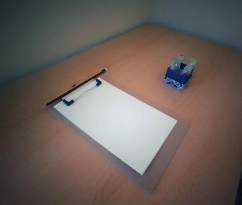 a piece of paper on a wooden table with a pen at Hostal Pensión Mar de Plata in Lugo
