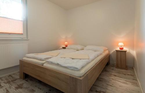1 dormitorio con 1 cama con 2 lámparas en F-1108 Häuser Prosnitz Haus16 Terrasse, Gartennutzung, en Gustow