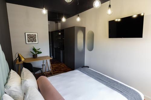 a bedroom with a bed and a flat screen tv at BlackBrick Cape Town Foreshore in Cape Town