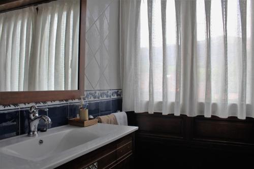 Noriega的住宿－Casa La Carrera - Casas de Los Picos，一间带水槽和镜子的浴室以及窗户。