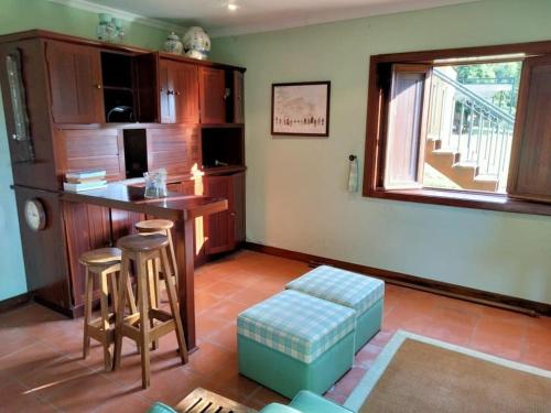 a kitchen with a table and a bar with stools at Confort, fun and leisure in Douro Rural Space in Sande