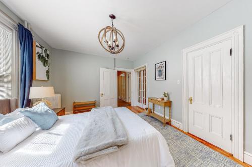 a bedroom with a white bed and a chandelier at Cumberland Casa - A in Portland