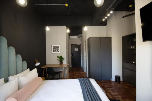 a bedroom with a large bed and a table at BlackBrick Cape Town Foreshore in Cape Town