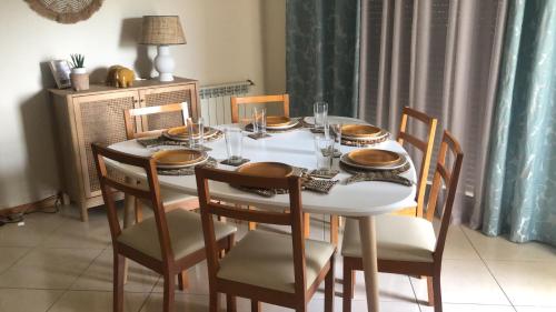 ナザレにあるNazare Marのダイニングルームテーブル(椅子付)、白いテーブル(皿付)