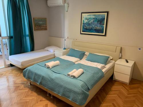 - une chambre avec 2 lits et des serviettes dans l'établissement Villa Bose, à Brela