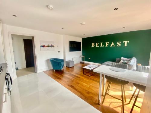 ein Wohnzimmer mit einer grünen Wand mit dem Wort Belfast drauf in der Unterkunft Amazing City Centre 1 bedroom Apartment with Balcony LGBTQ Friendly in Belfast