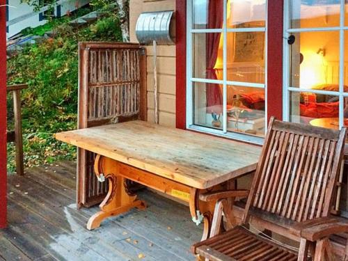 eine Holzbank auf der Veranda eines Hauses in der Unterkunft 5 person holiday home in TEGEFJ LL in Ängena