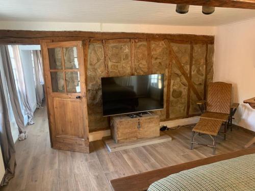 a room with a television and a room with a bed at Fermette La bergerie in Cormont