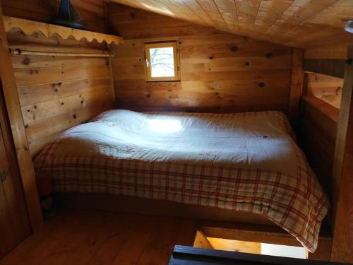 a bedroom in a log cabin with a bed in it at Chalet 1 chambre in Chenecey-Buillon
