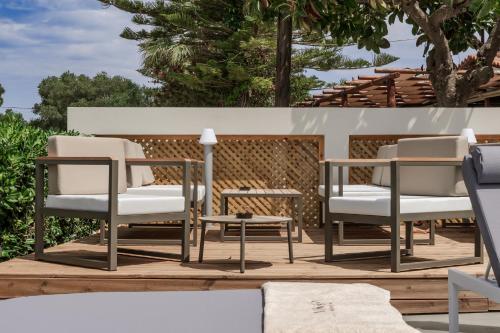 a group of chairs and a table on a deck at Nikon Boutique Hotel in Kalamaki