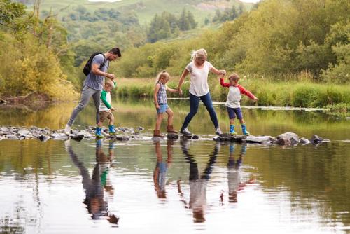a group of people crossing a body of water at Gasthaus & Hotel Drei Lilien in Werbach