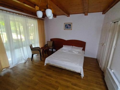 um quarto com uma cama, uma mesa e uma cadeira em Lipowy Przylądek- Domek 12 