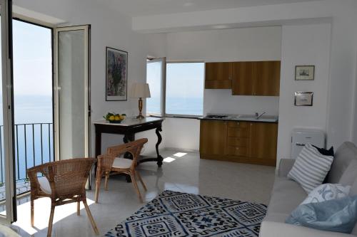 a kitchen and a living room with a table and chairs at IL GIARDINO SELVATICO DI SUCCELLARIO - APARTMENTS in Ischia