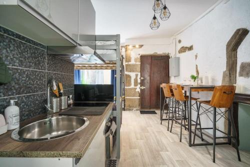 une cuisine avec un évier et un comptoir avec un bar dans l'établissement Cabana & Le Petit Rousseau - Proche du Lac, à Annecy