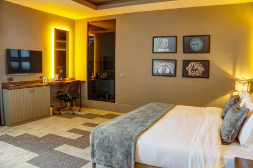 a bedroom with a bed and a desk with a computer at Four Mansions Hotel in Kayseri