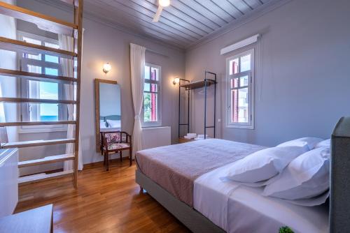 ein Schlafzimmer mit einem Bett und zwei Fenstern in der Unterkunft Sunset English Villas in Paralía