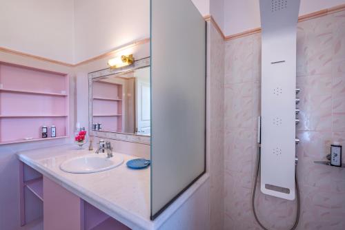 a bathroom with a sink and a mirror at Sunset English Villas in Paralía