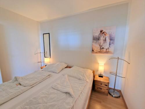 una camera da letto con un letto e un dipinto sul muro di Ferienpark E06-001 Ferienpark a Heiligenhafen