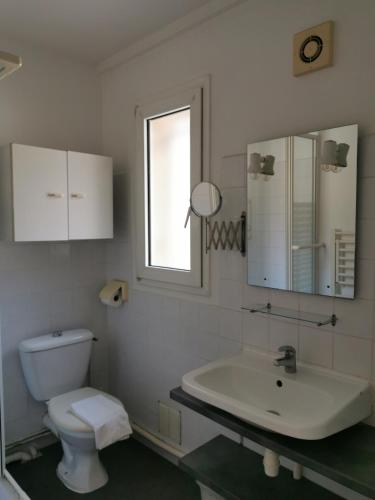 une salle de bain blanche avec un lavabo et des toilettes dans l'établissement Les studios de Marie, à Avignon