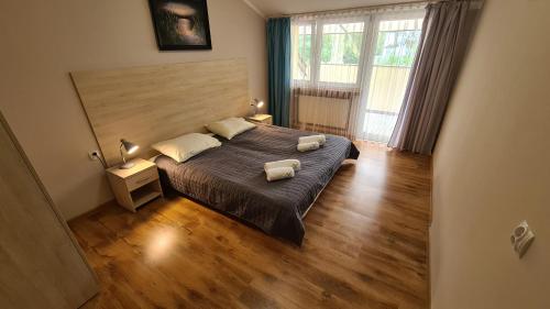 a bedroom with a large bed with two pillows on it at Zacisze Natura Tour in Spała