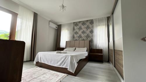 1 dormitorio con 1 cama grande con sábanas blancas en Sea life Trabzon, en Trabzon