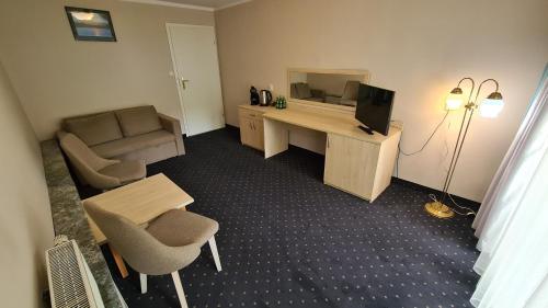 a room with a desk with a computer and a chair at Zacisze Natura Tour in Spała