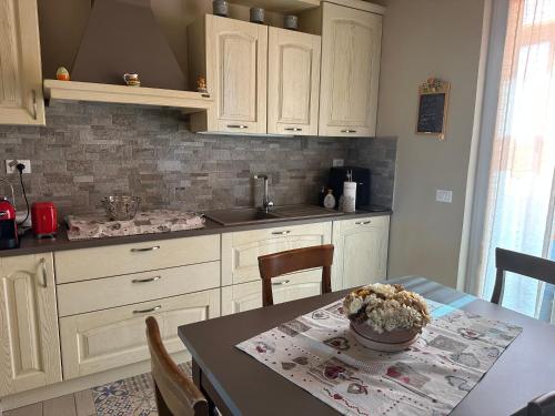 a kitchen with white cabinets and a table with a bowl on it at Casa Alessia in Lucca