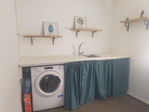 a laundry room with a washing machine under a counter at Casa Charo - Sardiñeiro in Fisterra