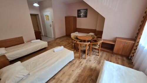 a room with two beds and a table and chairs at Zacisze Natura Tour in Spała