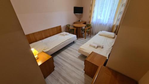 a small room with two beds and a table at Zacisze Natura Tour in Spała