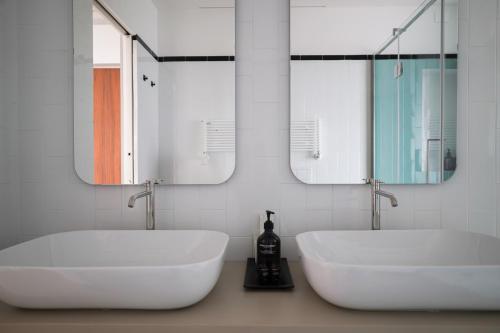 a bathroom with two sinks and two mirrors at Villa ALMANA in Cernobbio