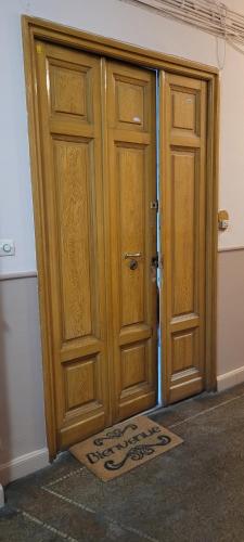 une porte en bois avec un tapis devant elle dans l'établissement Studio proche gare de Toulon, à Toulon