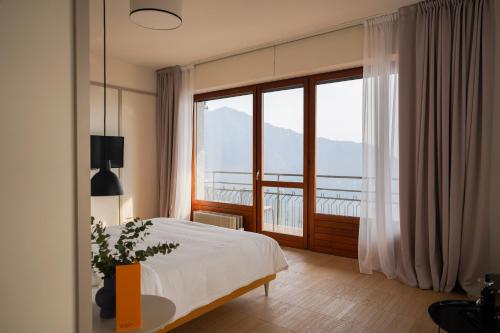 ein Schlafzimmer mit einem Bett und einem großen Fenster in der Unterkunft Villa ALMANA in Cernobbio