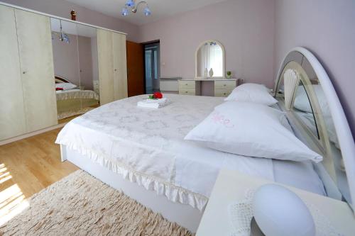 a bedroom with a white bed and a mirror at Apartments Adrian in Bibinje
