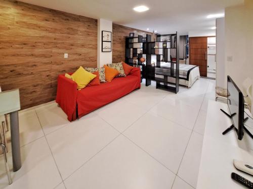 sala de estar con sofá rojo y dormitorio en Flat Felipe de Oliveira, en Río de Janeiro
