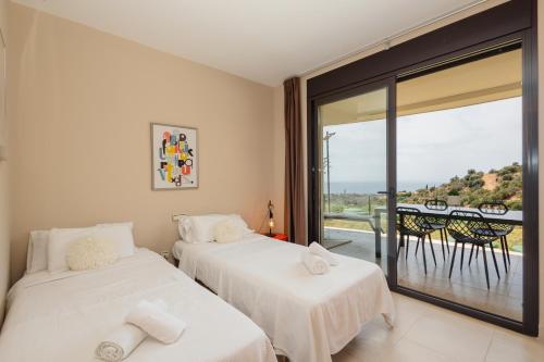 Duas camas num quarto com varanda em Moderno apartamento vacacional con increbles vistas al mar con spa y gimnasio em Marbella