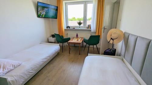 Pokój z 2 łóżkami, stołem i oknem w obiekcie Dom nad Jeziorem w mieście Szczedrzyk