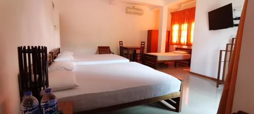 a bedroom with two beds and two bottles of water at Rajarata Family Resort in Anuradhapura