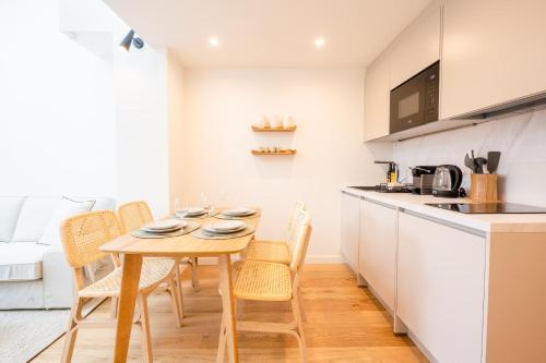 une cuisine et une salle à manger avec une table et des chaises en bois dans l'établissement Le Duplex Vaugelas atypique en plein Centre Ville, à Annecy