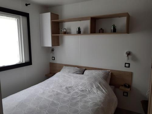 サン・ジャン・ド・モンにあるmobilhomeのベッドルーム(白いベッド1台、窓付)