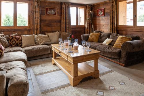 - un salon avec des canapés et une table avec des verres à vin dans l'établissement Chalet Grand Togadere, aux Gets