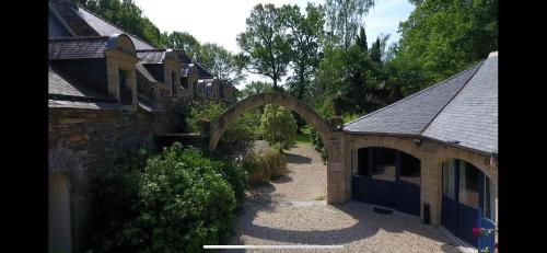 an archway between two buildings in a yard at Le Clos Saint Fiacre in Carentoir