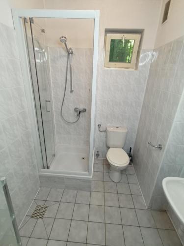 uma casa de banho com um chuveiro, um WC e um lavatório. em Lipowy Przylądek- Domek 15 